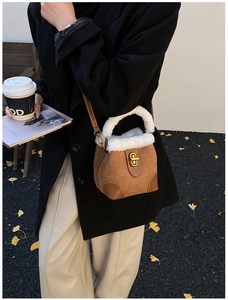 Détail du mini sac seau en daim marron avec fourrure blanche et fermoir doré tournant