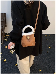 Sac seau en daim pelucheux marron porté par un mannequin en extérieur en automne