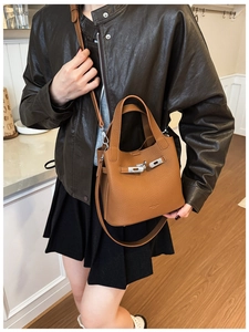 Close-up of brown litchi pattern leather bucket bag with silver metal turn-lock