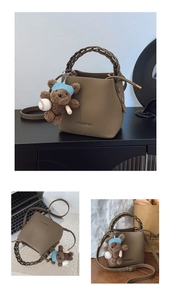Détail du sac seau en cuir grainé avec poignée tressée et breloque ours décorative