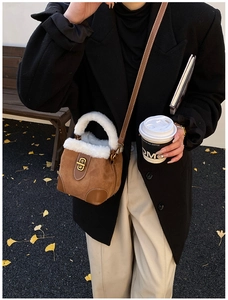 Détail du sac seau en daim marron avec bordure en peluche blanche et fermoir doré