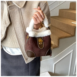 Détail du sac seau en daim marron avec bordure en fourrure blanche et fermoir doré