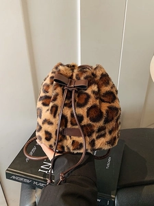 Faux fur leopard print bucket bag with drawstring closure and brown leather bow detail