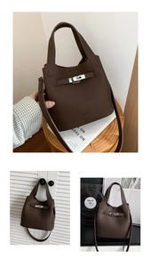 Detail of dark brown pebble leather bucket bag with silver lock and buckle strap