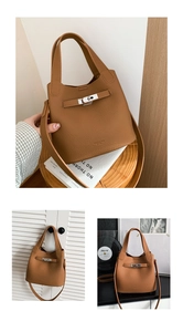 Detail of brown lychee grain leather bucket bag with silver lock and dual handles