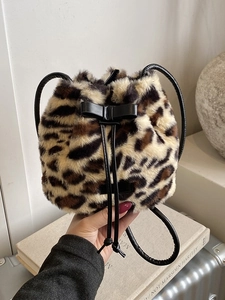 Plush leopard print bucket bag with drawstring closure and black leather top handle
