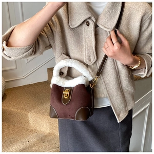Détail du sac seau vintage en daim avec bordure en peluche et fermoir doré chic