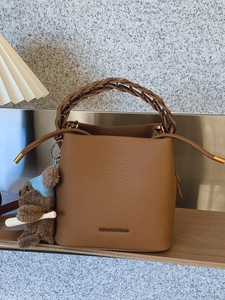 Sac seau marron avec poignée tressée, fermeture à cordon et breloque ourson