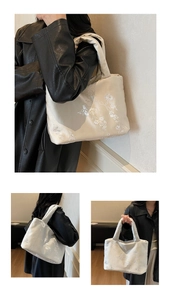 Detail of white embroidered tote bag featuring floral patterns and wide carry handles