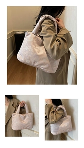 Detail of elegant Chinese embroidery on champagne jacquard tote bag with soft padded texture