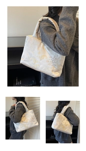 Detail of embroidered silk tote bag with golden dragon and floral patterns in ivory