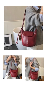 Detail der dunkelroten Beuteltasche mit Lederstruktur und Holzperlenanhänger