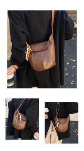 Makro-Detail der braunen Vintage-Eimertasche mit mattem Lederfinish und Holzperlen