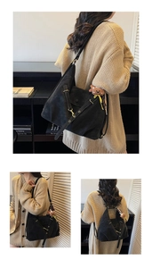 Macro detail of black suede tote bag showing metallic buckles and plush bear charm