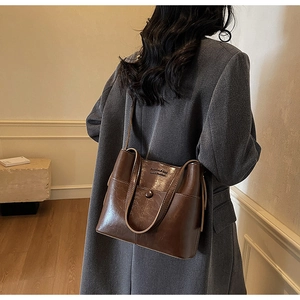 Detail of a vintage dark brown leather bucket bag with Fashion & Bag embossed text