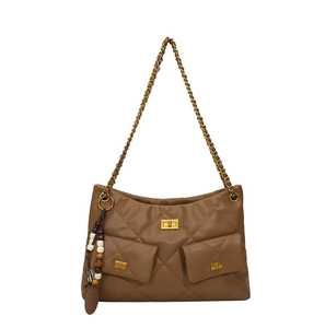 Detail of brown quilted leather bag with gold twist locks and beaded tassel charm