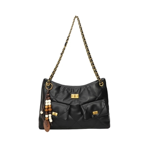 Detail of black quilted shoulder bag featuring gold twist locks and bead charm