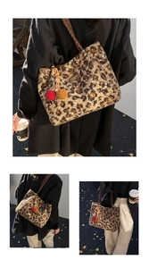Detail of leopard print plush tote bag with brown woven strap and colorful pom pom charms