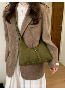 Detail shot of olive green suede shoulder bag with metal buckle on retro wool blazer