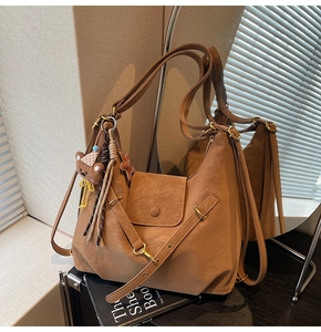 Détail du sac vintage marron avec sangle à boucle en métal et breloque ours mignon