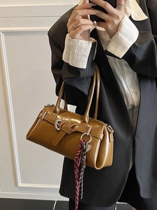 Caramel glossy leather pillow bag with belt buckle and floral scarf on top handles
