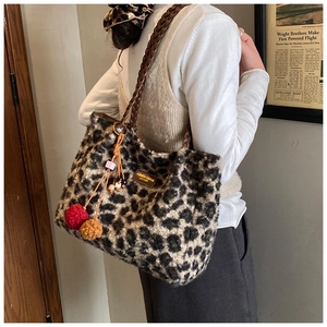 Detail of leopard print plush tote bag with woven strap and fashion leather tag