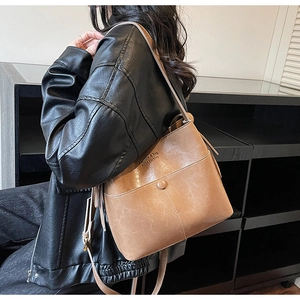 Detail of brown faux leather bucket bag with adjustable strap and vintage texture