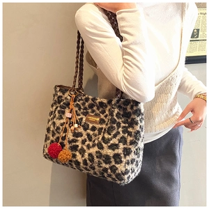Close-up of leopard print plush tote bag with woven handles and tassel charm