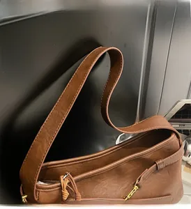 Détail des coutures et des finitions dorées sur le sac à bandoulière marron vintage