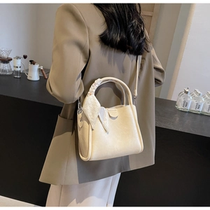 Detail of cream leather tote bag with silk scarf handle on a woman in a blazer