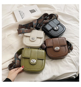 Detail of four colorful saddle bags with bohemian printed wide shoulder straps on white fabric