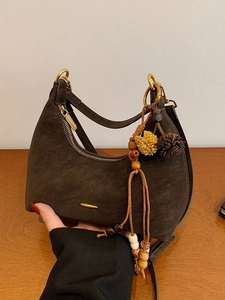 Braune Halbmond-Schultertasche mit Wildleder-Struktur und dekorativem Anhänger