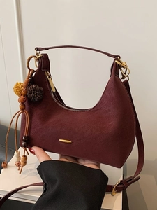 Burgunderrote matte Crescent Bag mit goldenem Reißverschluss und Plüsch-Anhänger