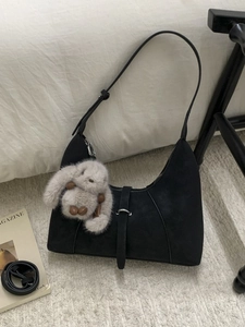 Fashionable black faux suede crescent bag with cute plush bunny charm and shoulder strap