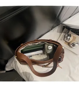 Vue intérieure montrant la grande capacité du sac à bandoulière en cuir marron vintage
