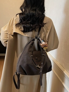 Grand sac fourre-tout rétro marron avec charme d'ours, porté par un mannequin en trench