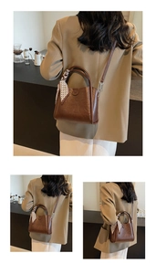 Détail du sac seau marron foncé avec foulard à motifs cœurs sur la poignée