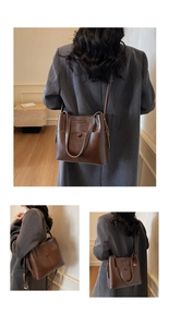 Detail of dark brown leather tote bag showing embossed lettering and snap button closure