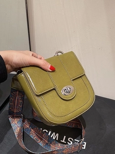 Green saddle crossbody bag with bohemian patterned wide strap and silver metal clasp