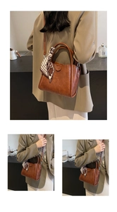 Détail d'un sac seau vintage marron caramel avec un foulard en soie sur la poignée