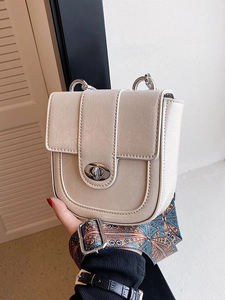 Minimalist beige saddle bag with silver twist lock and ethnic geometric strap