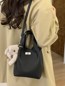 Minimalist black lychee leather bucket bag with silver lock and plush rabbit charm