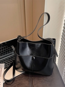 Minimalist black soft leather bucket bag with vintage glossy finish and shoulder strap