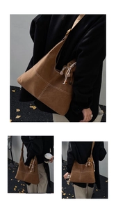 Detail of brown suede tote bag with white contrast stitching and a cute bear charm