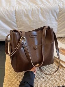 Brown vintage faux leather bucket bag with gold buckle and adjustable shoulder strap