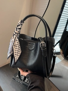 Black leather tote bag with silk scarf handle and adjustable strap for women