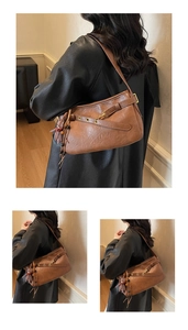 Détail du sac sous l'aisselle marron vintage avec texture cuir et breloque en ours