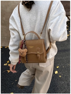 Brown vintage leather multi-way backpack shown on model with cute plush bear charm decoration