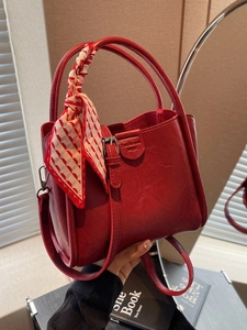 Modern red leather tote bag with silk scarf handle and adjustable strap for women