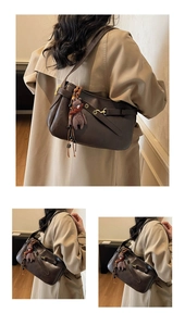 Détail d'un sac sous le bras rétro en cuir marron avec breloque ours et boucle dorée